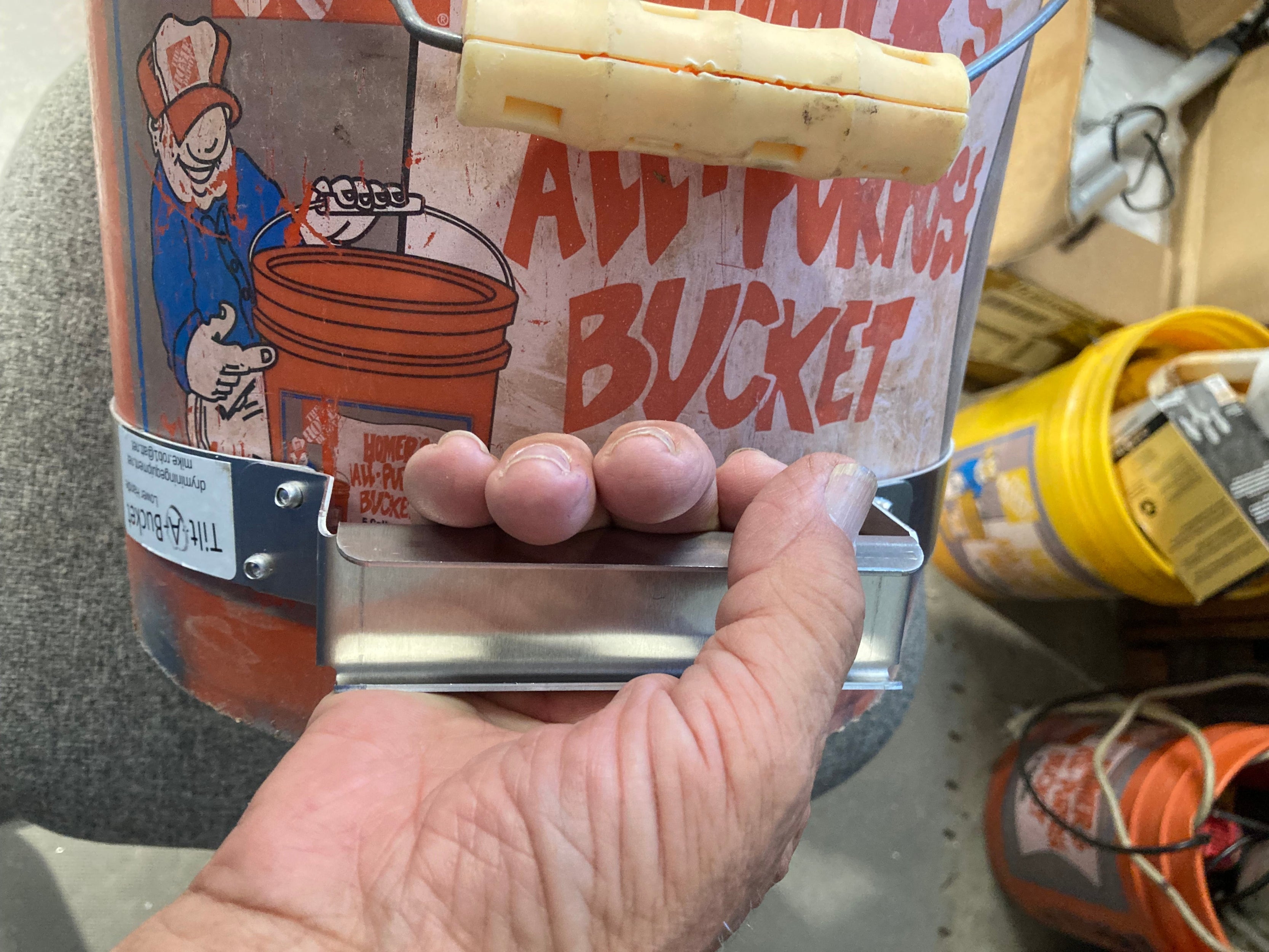 Close-up showing the bent-edge, smooth aluminum handle with extra clearance against the bucket wall for gloved hands.